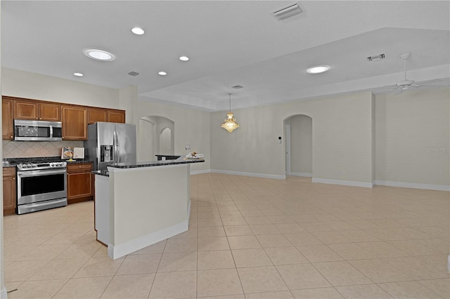 kitchen featuring ceiling fan, hanging light fixtures, tasteful backsplash, light tile patterned flooring, and appliances with stainless steel finishes