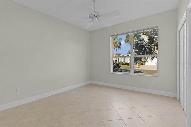 empty room with ceiling fan and light tile patterned flooring