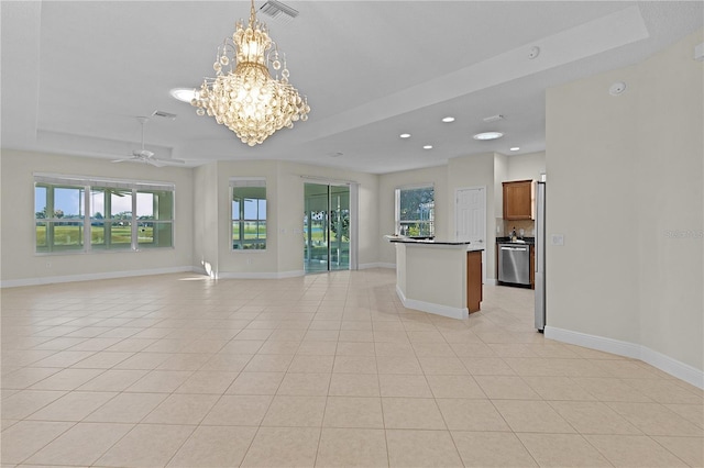 unfurnished living room featuring a raised ceiling, light tile patterned floors, and ceiling fan with notable chandelier