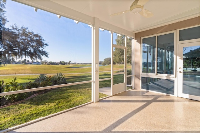 unfurnished sunroom with ceiling fan