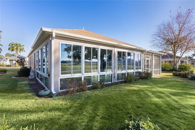 view of side of home with a lawn and a sunroom