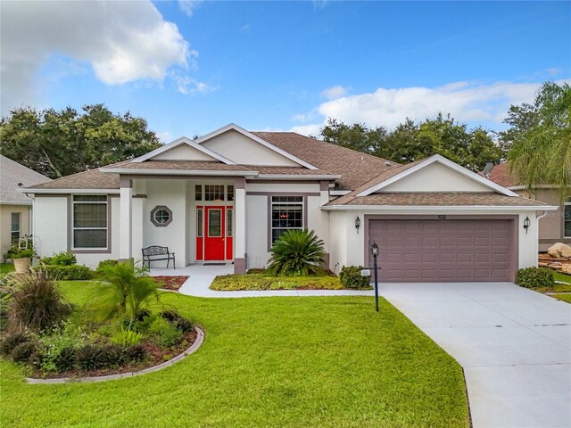 ranch-style house featuring a front lawn and a garage