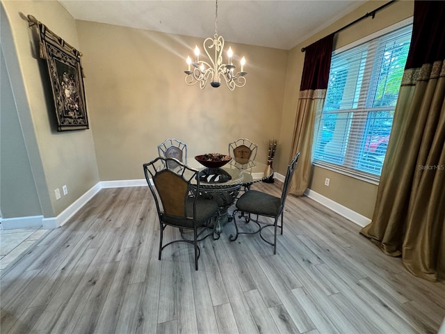 dining area with an inviting chandelier and light hardwood / wood-style flooring