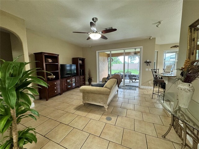 tiled living room with ceiling fan and a textured ceiling