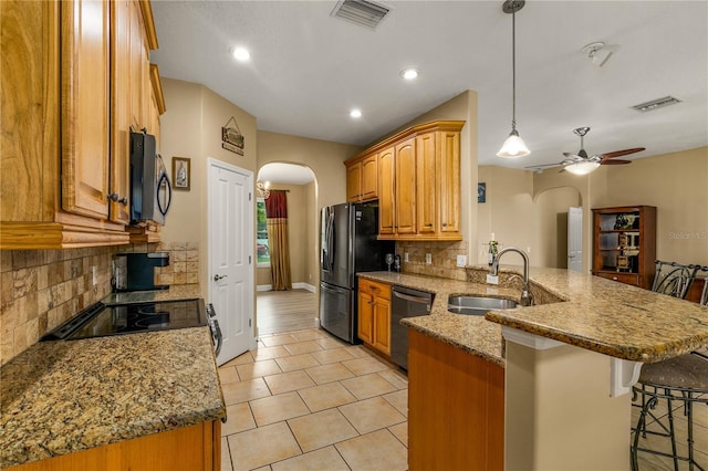 kitchen with a kitchen breakfast bar, black dishwasher, sink, and backsplash