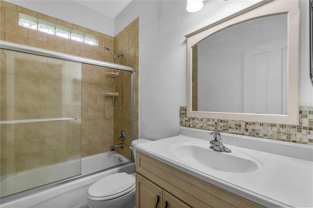 full bathroom with vanity, combined bath / shower with glass door, backsplash, and toilet