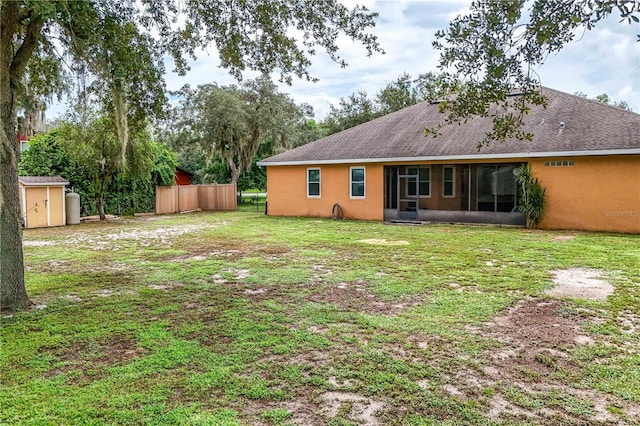 back of house with a shed and a lawn