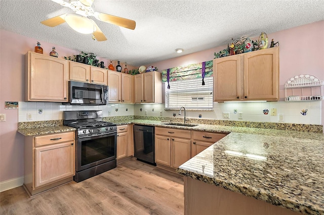 kitchen featuring black dishwasher, a sink, light brown cabinets, and range with gas stovetop