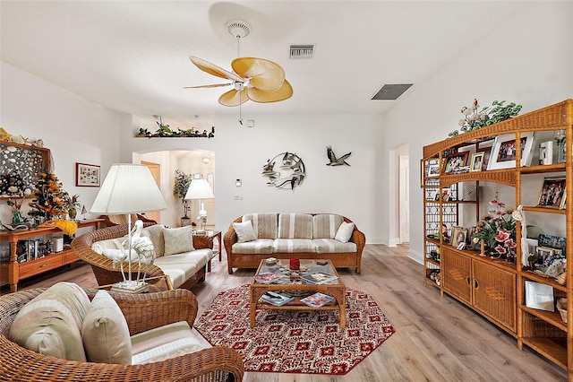 living area featuring arched walkways, visible vents, light wood-style flooring, and a ceiling fan