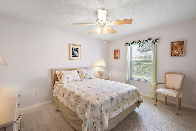 bedroom featuring light carpet, a textured ceiling, and baseboards