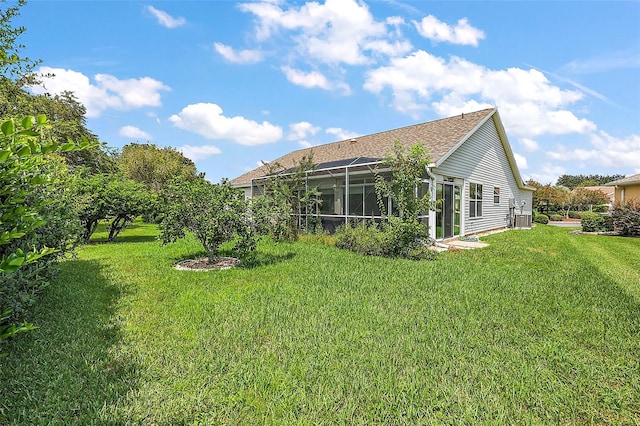 back of house featuring glass enclosure and a lawn