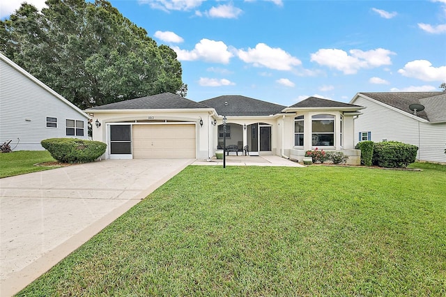 view of front of property featuring a front yard, concrete driveway, an attached garage, and stucco siding