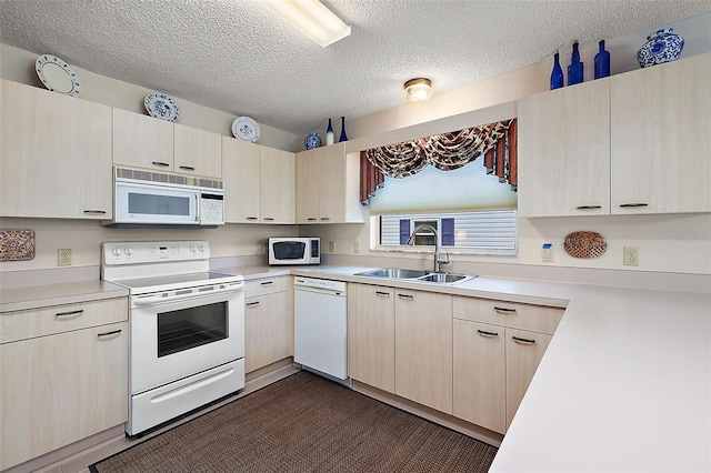 kitchen with sink, white appliances, a textured ceiling, and light brown cabinetry