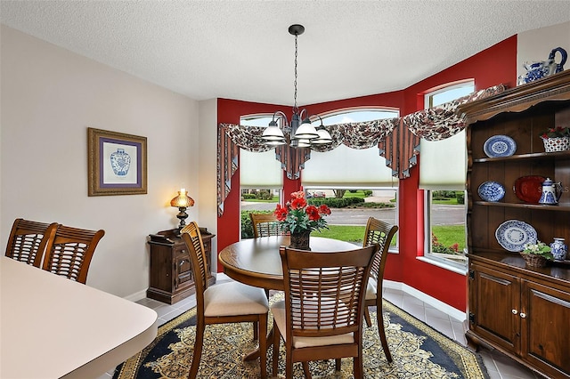 dining area featuring a notable chandelier, a textured ceiling, and light tile patterned floors