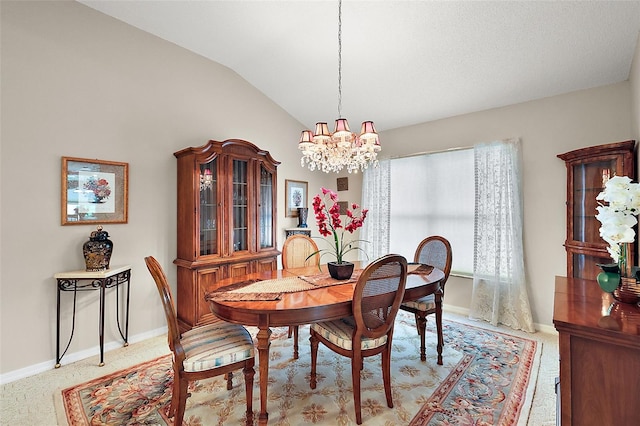 dining room featuring a notable chandelier, vaulted ceiling, and light colored carpet