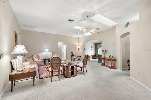 living room with ceiling fan and a skylight