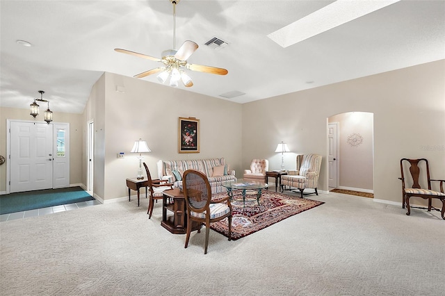 living room featuring ceiling fan, carpet, and lofted ceiling with skylight