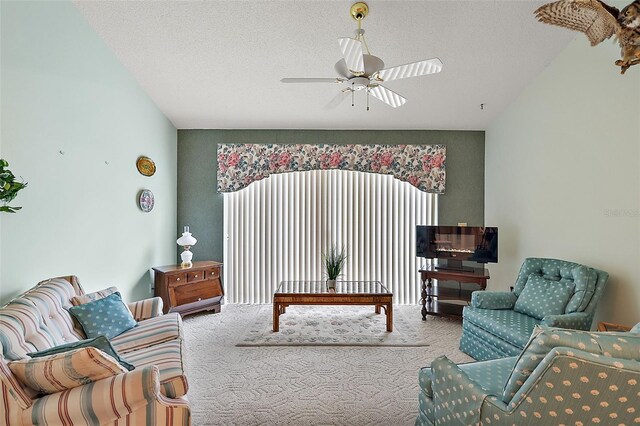 carpeted living room with ceiling fan and a textured ceiling