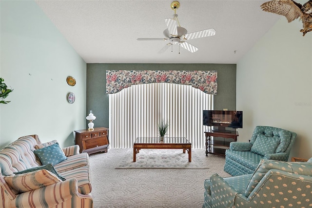 sitting room featuring carpet floors, ceiling fan, and a textured ceiling