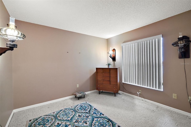 interior space with a textured ceiling and baseboards