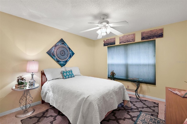 carpeted bedroom featuring ceiling fan and a textured ceiling