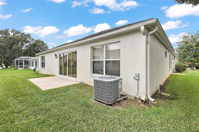 back of property featuring stucco siding, a yard, a patio, and central air condition unit