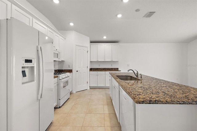 kitchen featuring dark stone counters, sink, white cabinetry, white appliances, and light tile patterned floors