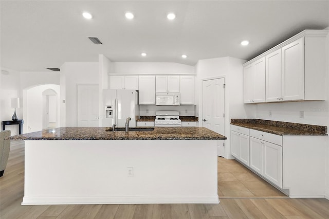 kitchen featuring sink, light wood-type flooring, white appliances, white cabinetry, and a center island with sink