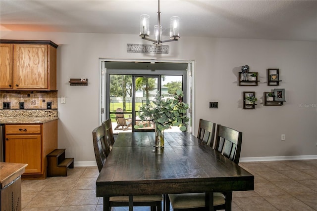 dining space with light tile patterned floors, baseboards, and a chandelier