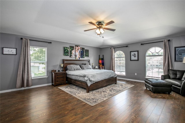 bedroom featuring a ceiling fan, dark wood-style flooring, multiple windows, and baseboards