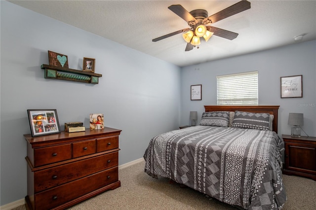 bedroom with carpet floors, ceiling fan, baseboards, and a textured ceiling