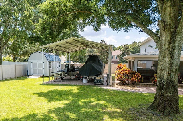 view of yard featuring a storage shed, a carport, an outbuilding, and a fenced backyard