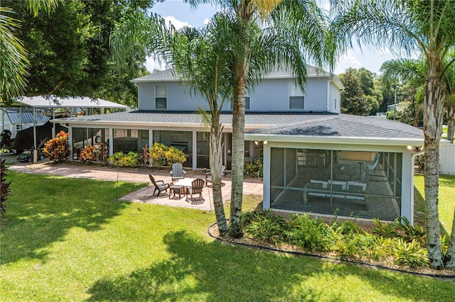 back of property featuring a sunroom, roof with shingles, a patio, and a yard