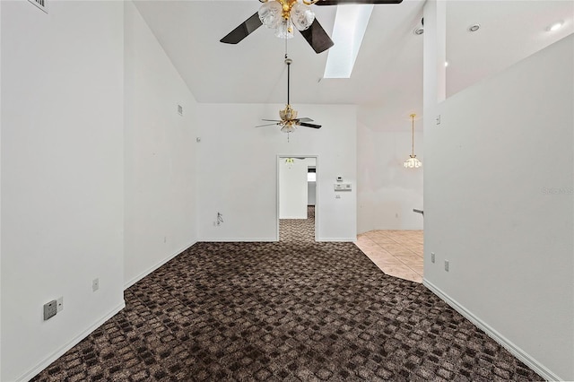 unfurnished room with ceiling fan, lofted ceiling with skylight, and light colored carpet