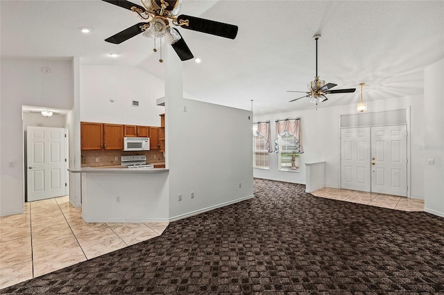 unfurnished living room with light tile patterned flooring, high vaulted ceiling, and ceiling fan