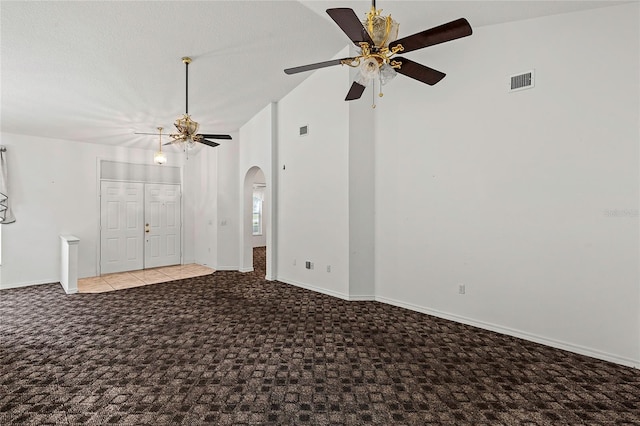 tiled empty room with ceiling fan and high vaulted ceiling