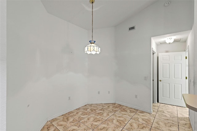 unfurnished dining area with vaulted ceiling and light tile patterned flooring