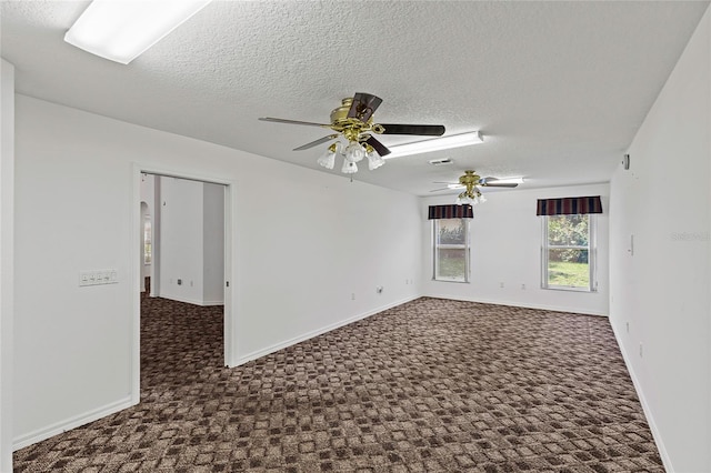 carpeted spare room featuring ceiling fan and a textured ceiling