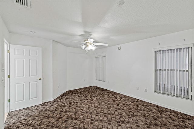 carpeted spare room with ceiling fan and a textured ceiling