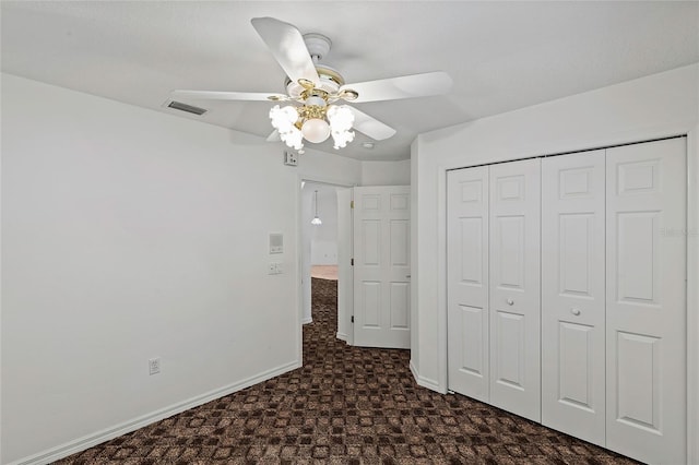 unfurnished bedroom with ceiling fan and a closet