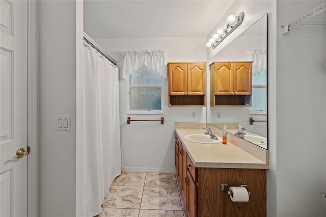 bathroom featuring a textured ceiling, vanity, and tile patterned floors