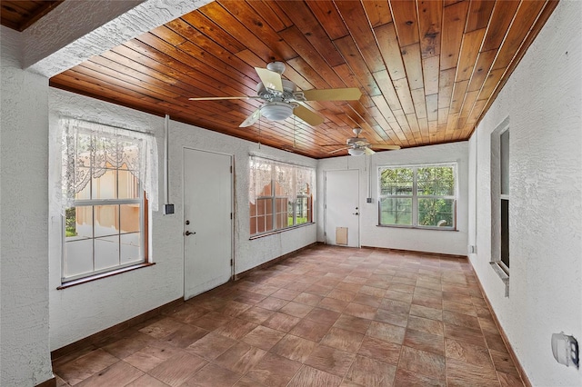 unfurnished sunroom with ceiling fan and wood ceiling