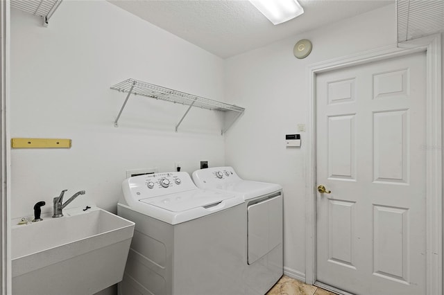 laundry area featuring sink, separate washer and dryer, and light tile patterned floors