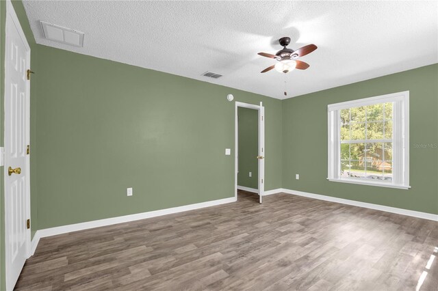 spare room with hardwood / wood-style flooring, a textured ceiling, and ceiling fan