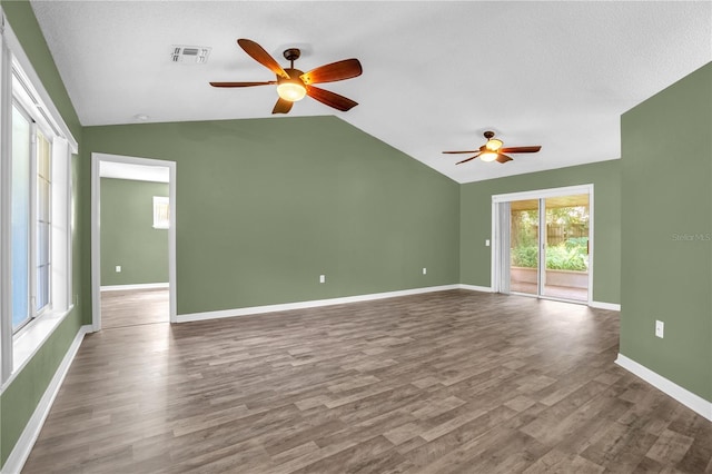 spare room featuring ceiling fan, vaulted ceiling, hardwood / wood-style flooring, and a textured ceiling