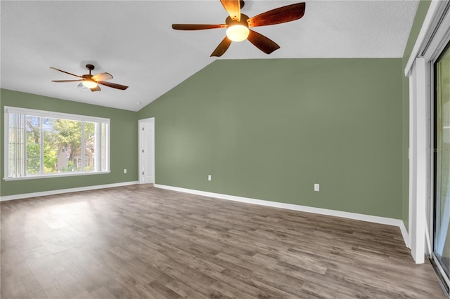 unfurnished room featuring ceiling fan, hardwood / wood-style flooring, and lofted ceiling