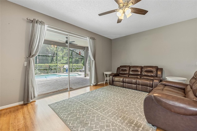 living room featuring hardwood / wood-style floors, a textured ceiling, and ceiling fan