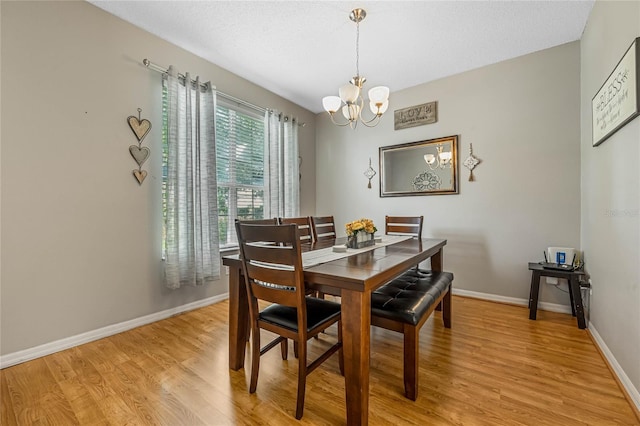 dining area with a chandelier and light hardwood / wood-style flooring