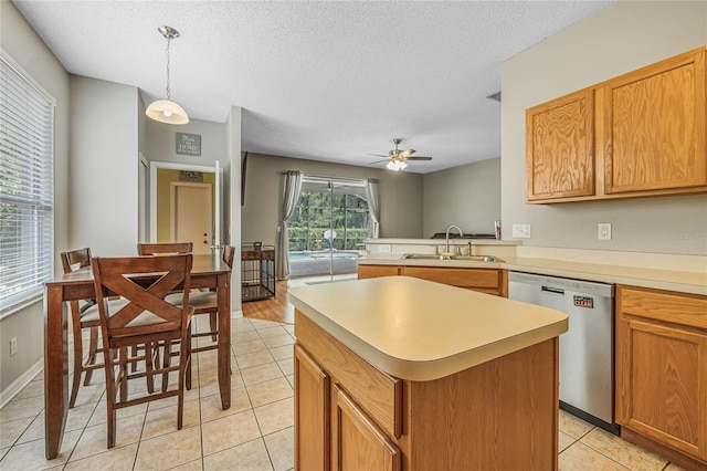 kitchen featuring ceiling fan, sink, dishwasher, a kitchen island, and hanging light fixtures