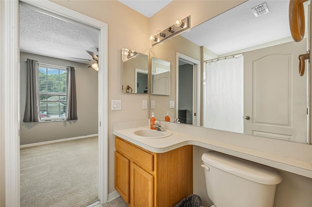 bathroom featuring a shower with curtain, a textured ceiling, vanity, ceiling fan, and toilet